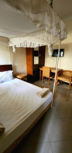 a bedroom with a large bed and a table at Tarakea Lodge in Mbuguni
