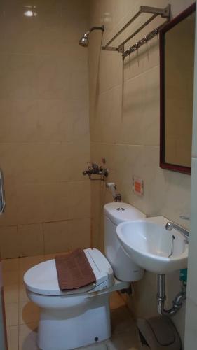 a bathroom with a white toilet and a sink at The Cabin Hotel Ngupasan in Yogyakarta