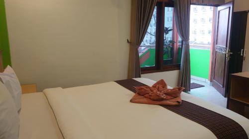 a white bed with a towel on top of it at The Cabin Hotel Ngupasan in Yogyakarta