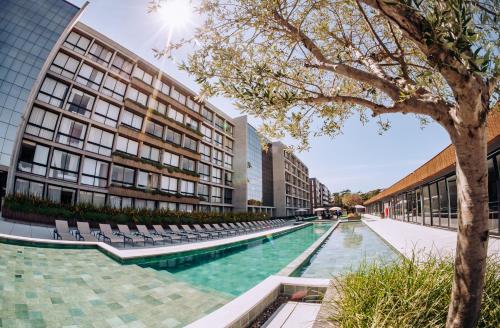 a swimming pool in front of a building at Resort com Piscina Aquecida e Garagem em Xangri-lá in Xangri-lá