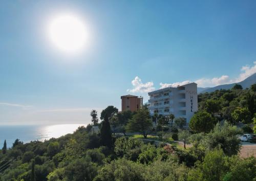 a building on a hill with the ocean in the background at Hotel Palasa in Palasë