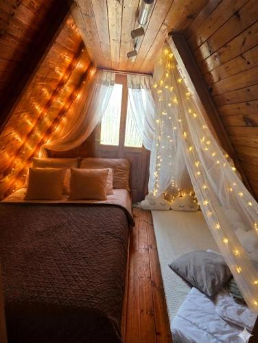 a bedroom with a bed with a canopy and lights at Napsugár Kakasvár in Orosháza