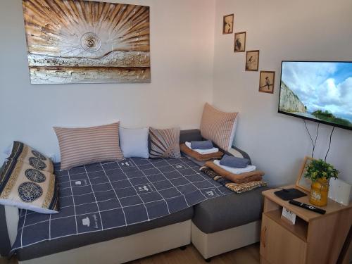 a small room with a bed and a tv at Sunshine- self sheck in in Čačak