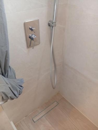 a shower with a hose in a bathroom at Sevi - Irene Studios in Masouri
