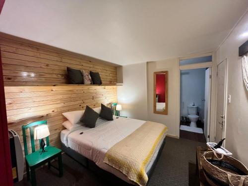 a bedroom with a large bed with a wooden wall at Treehouse Patagonia in Puerto Natales