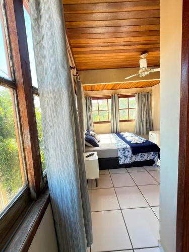 a bedroom with a bed in a room with windows at Pousada Azul do Mar by BlueOcean in Arraial do Cabo