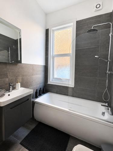 a bathroom with a bath tub and a sink at Queenie's Nook in North Shields