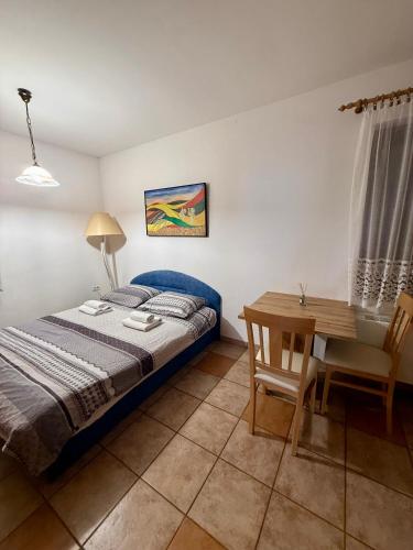 a bedroom with a bed and a wooden table at Turistična kmetija Birsa in Dobravlje