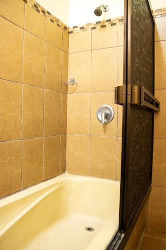 a bathroom with a bath tub with a mirror at Hotel D'Lucia - Quebrada Ganado, Jaco, Costa Rica in Puntarenas