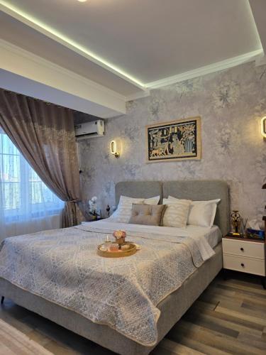 a bedroom with a large bed with a tray on it at Apartment with FREE Massage chair Fergana in Fergana