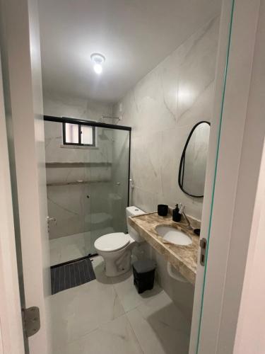 a bathroom with a toilet and a sink and a mirror at Casa Aquiraz in Aquiraz