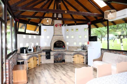 a large kitchen with a fireplace in a house at Casa Drumetului in Comarnic