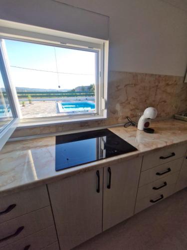 a kitchen with a counter with a large window at Villa Jopi in Neum