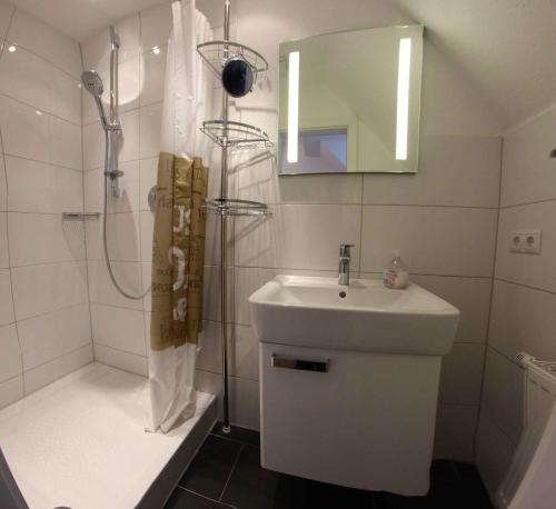 a white bathroom with a sink and a shower at Natursteinvilla am Goldberg in Hagen