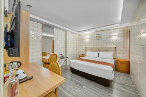 a hotel room with a bed and a desk and a table at Suwara Hotel Kepong KL in Kuala Lumpur