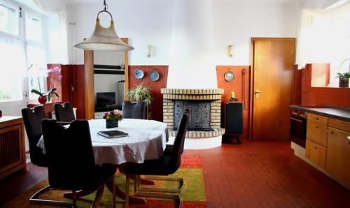 ein Esszimmer mit einem Tisch und einem Kamin in der Unterkunft Natursteinvilla am Goldberg in Hagen