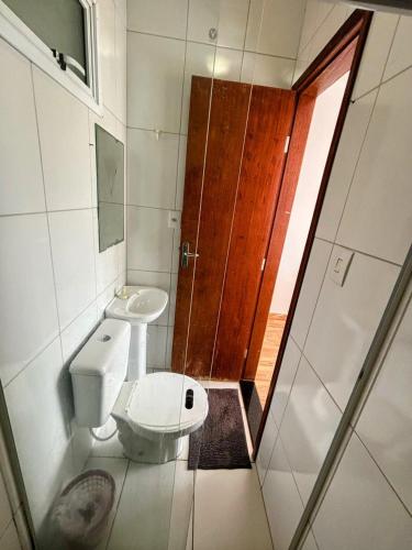 a small bathroom with a toilet and a shower at Pousada Sol & Mar Jacaraìpe ES in Serra