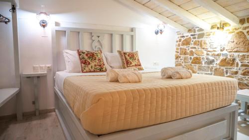 a bedroom with a bed with two pillows on it at Rodakas Rooms-Dafni in LivadhokhÃ³rion