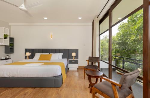 a bedroom with a bed and a balcony at Villa Oasis in Kataragama
