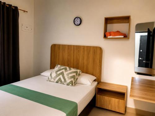 a bedroom with a bed and a clock on the wall at Hostal Monte Verde in Zaragoza