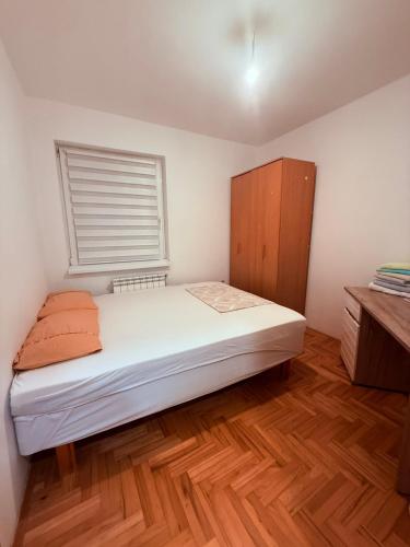 a small bedroom with a bed and a window at Stari Cerak in Žarkovo
