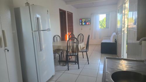 a kitchen and dining room with a table and a refrigerator at Recanto Dos Vargas - Seu refúgio em Floripa com atendimento dos anfitriões in Florianópolis