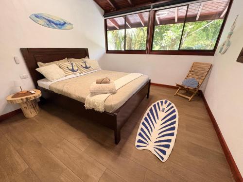 a bedroom with a bed and a chair and windows at Pacheco Villa in Drake