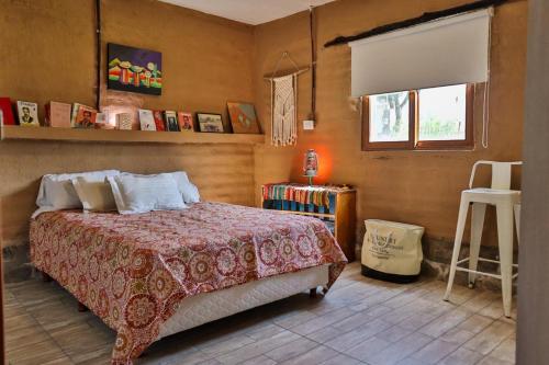a bedroom with a bed and a window and a stool at Marta Maria in El Rodeo