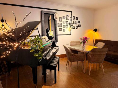 a living room with a piano and a table at Hotel Orange Kutaisi in Kutaisi