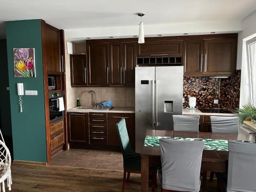 a kitchen with a table and a refrigerator at Cora Lego Apartment City View near Stadium & Sinfonia Varsovia Optional Parking in Warsaw