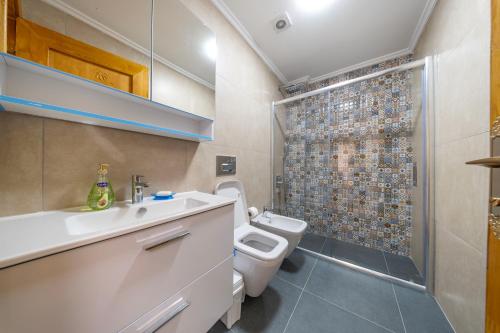 a bathroom with a toilet sink and a shower at Adali Aparts in Side