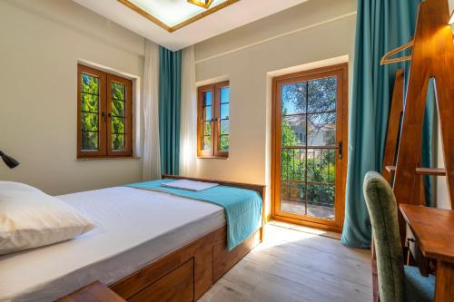 a bedroom with a bed and a desk and windows at Adali Aparts in Side