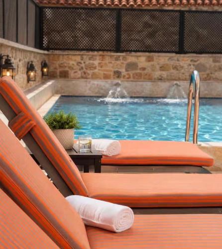 a swimming pool with orange cushioned chairs and a swimming pool at Morea Kaleiçi-Adults Only in Antalya