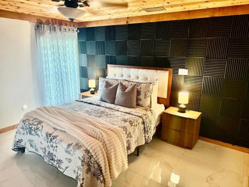 a bedroom with a large bed and two lamps at Wood & White in Hialeah