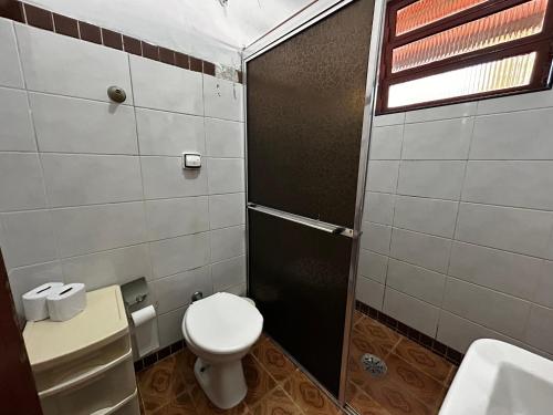 a small bathroom with a toilet and a shower at Chacara c piscina ampla em Pedro de toledo in Pedro de Toledo