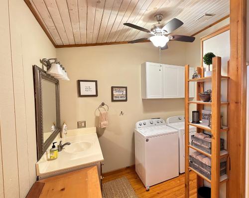 a bathroom with a sink and a washing machine at Cozy Beaver Lake Getaway in Lowell
