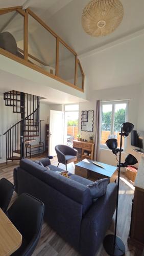 a living room with a blue couch and a table at L'escale du Cap A in Barneville-Carteret