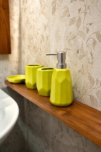 a shelf with a yellow soap dispenser in a bathroom at Apartment Waskaduwa in Waskaduwa