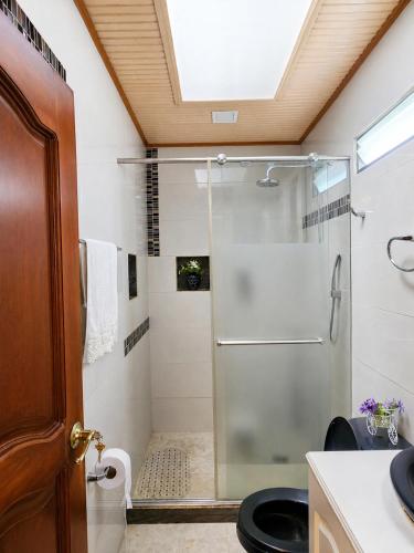a bathroom with a shower with a glass door at Casa campestre cerca de termales con WiFi y parqueadero in Santa Rosa de Cabal