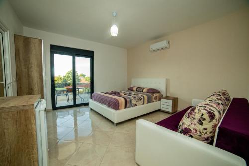 a bedroom with two beds and a balcony at Apartments IL GUSTO in Ulcinj
