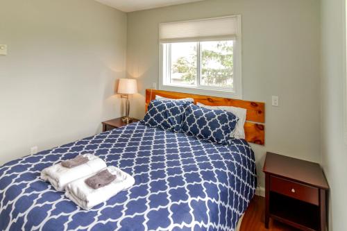 a bedroom with a blue and white bed and a window at Westlake Cottage - Hillier Lodge in Wellington