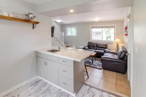 a kitchen with a sink and a living room at Westlake Cottage - Hillier Lodge in Wellington