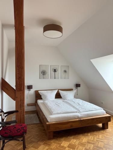 a bedroom with a bed and a chair at Deichoase bei Friesens mit Sauna in Barsfleth