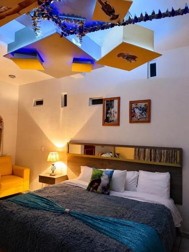 a bedroom with a large bed and a ceiling with lights at Hotel Museo Carnaval in Huejotzingo