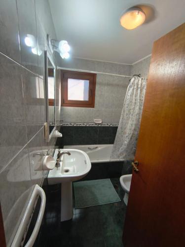 a bathroom with a sink and a tub and a toilet at Jardín del Piltri in El Bolsón
