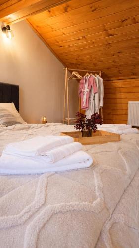 a bed in a room with clothes hanging from a ceiling at Къща за гости ХидроТера - Велинград in Velingrad