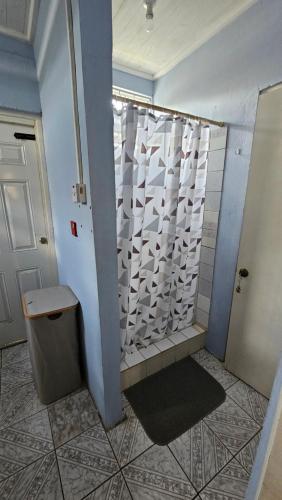 a bathroom with a shower with a toilet and a sink at Hidden Bungalow in Roseau