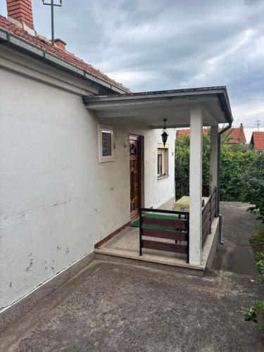 a porch of a white house with a bench at Vila Vuković in Leskovac