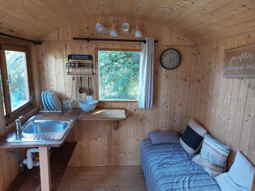 a kitchen with a couch and a sink in a room at La roulotte enchantée in Le Boissenet