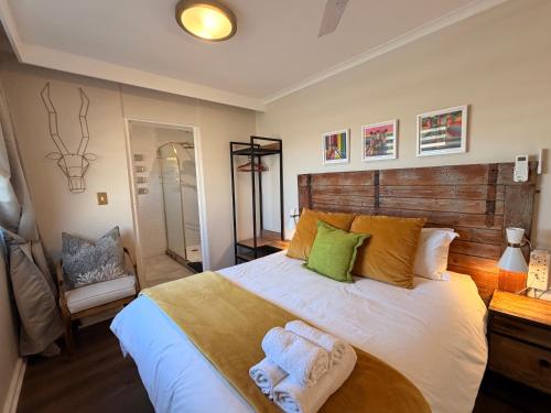 a bedroom with a large bed with towels on it at Dolphin Circle Bed and Breakfast in Plettenberg Bay